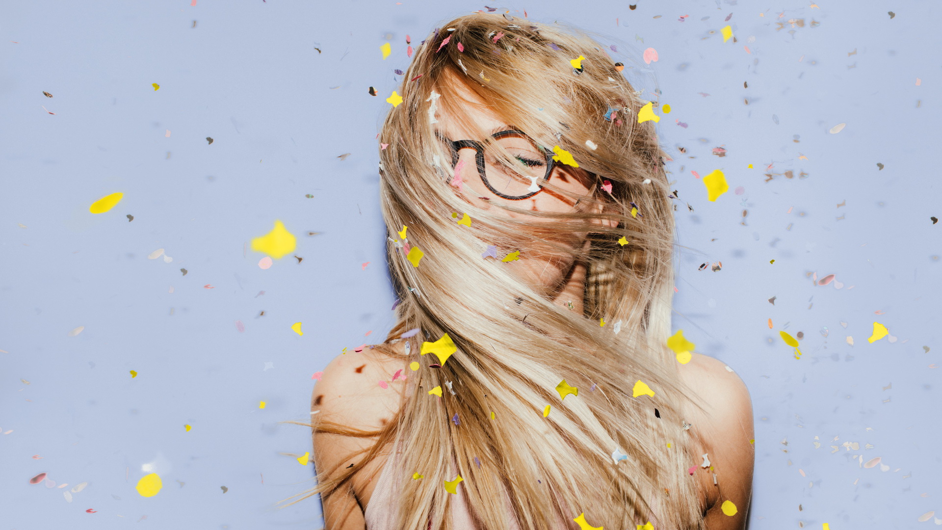 Photo of a young woman celebrating her youth, beauty and femininity - dancing while confetti are falling